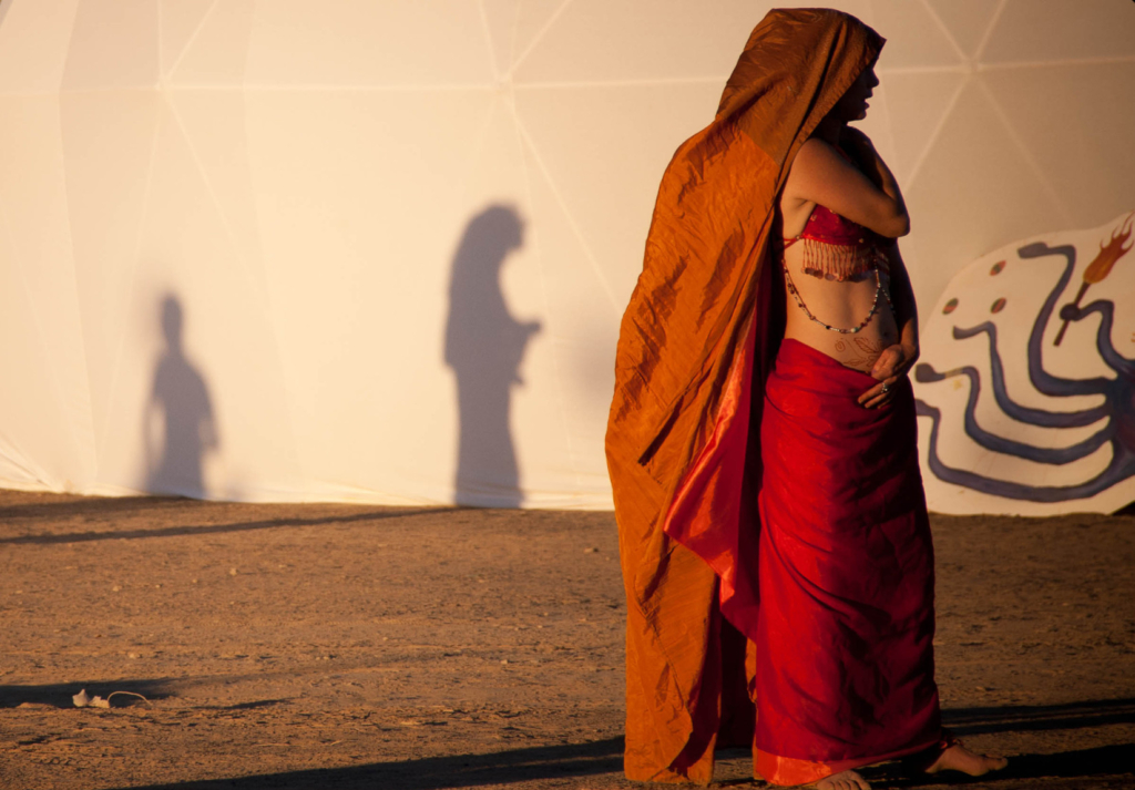 A woman stands by a tent at AfrikaBurn