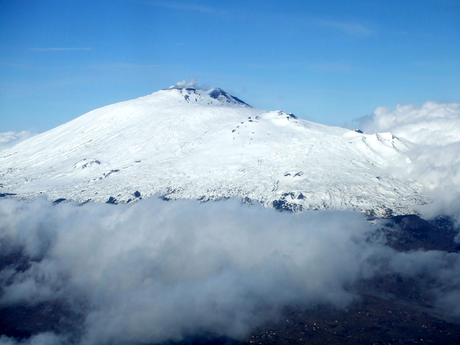 Snow-covered Mount Etna rises out of the clouds