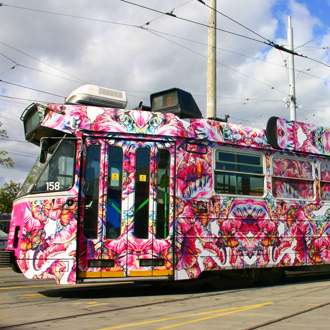 A vibrant tram painted heavily with pink shapes