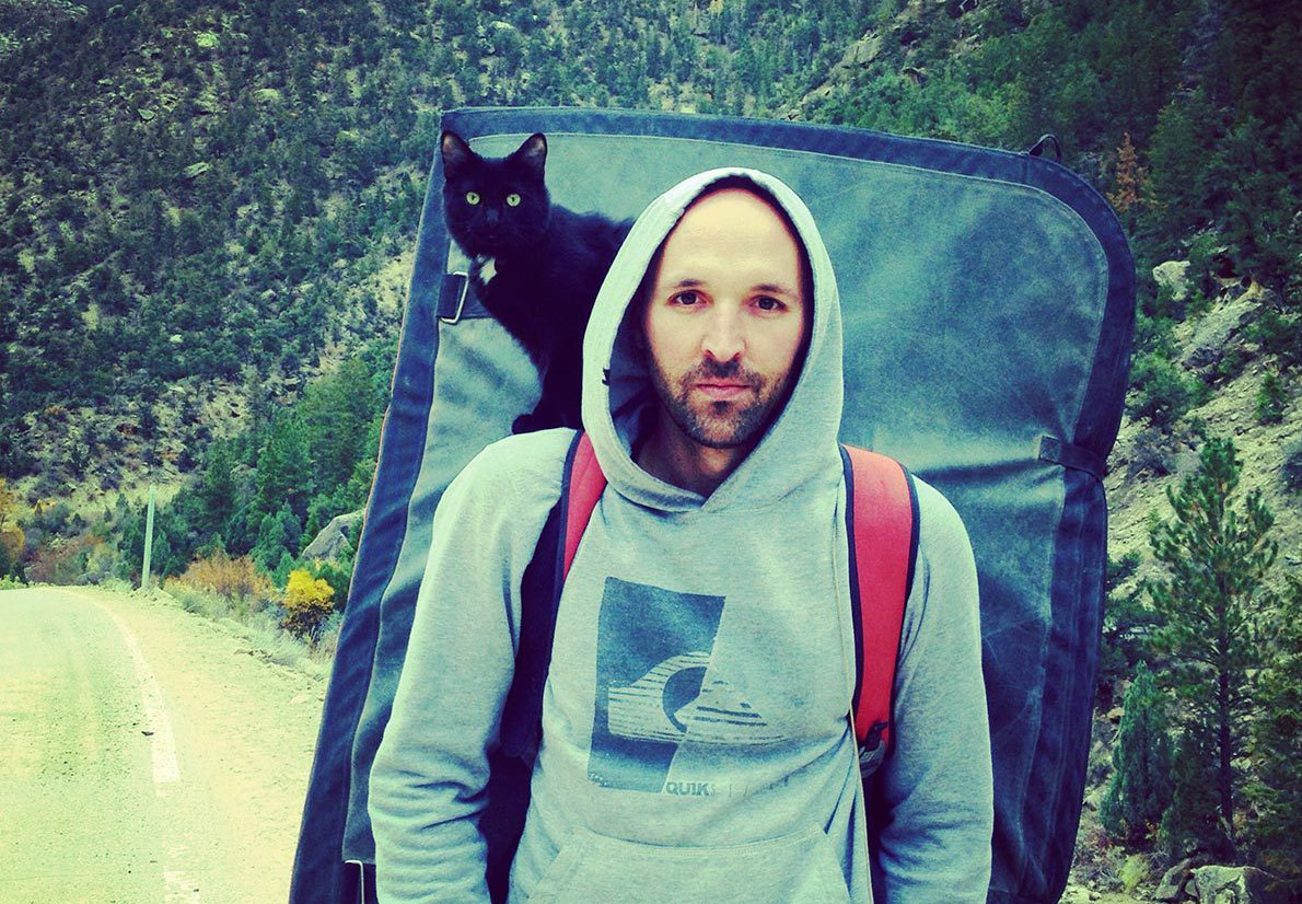 Backpacker walks with a cat riding on his shoulders
