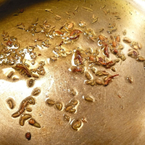 A tempered spice mix and the act of tempering spices in hot oil.